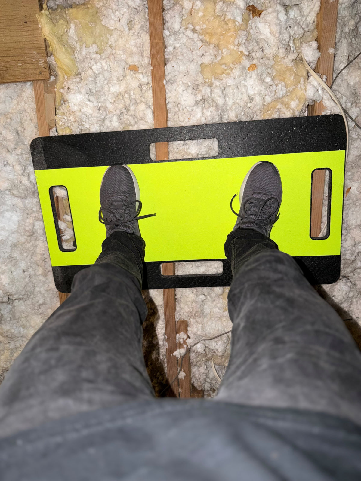 a person standing on an attic safety platform in an attic